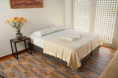 a bedroom with a bed with a vase of flowers on it at Villa frente el mar cartagena de indias in Cartagena de Indias