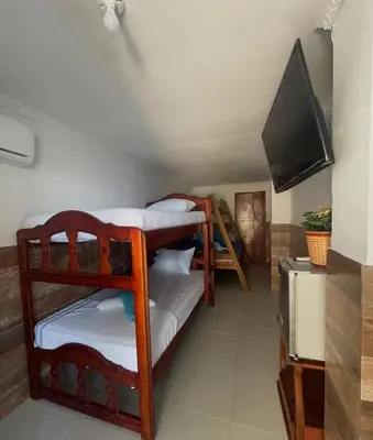 a room with two bunk beds and a flat screen tv at Apartamento frente al mar orilla beach house in Playa Punta Arena