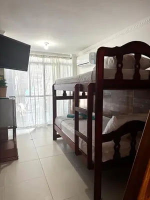 a room with two bunk beds and a television at Apartamento frente al mar orilla beach house in Playa Punta Arena
