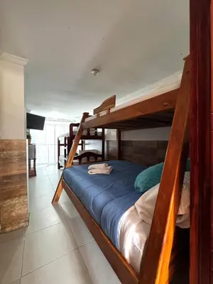 a bedroom with two bunk beds with blue sheets at Apartamento frente al mar orilla beach house in Playa Punta Arena