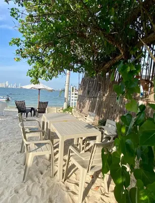 a picnic table and chairs on the beach at Apartamento frente al mar orilla beach house in Playa Punta Arena