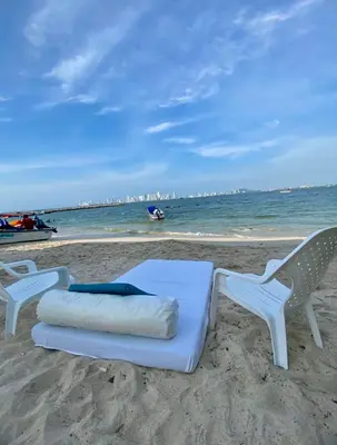 two chairs and a bed on the beach at Apartamento frente al mar orilla beach house in Playa Punta Arena