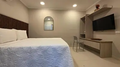 a bedroom with a bed and a flat screen tv at Hotel Casa La Tablada Aeropuerto in Cartagena de Indias
