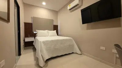 a bedroom with a bed and a flat screen tv at Hotel Casa La Tablada Aeropuerto in Cartagena de Indias