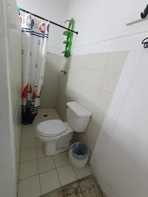 a bathroom with a toilet and a shower curtain at Habitación con medio baño en el barrio ciudad jardín Barranquilla in Barranquilla