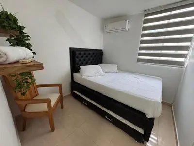 a bedroom with a bed and a chair and a window at Conjunto Residencial Caribe Campestre in Coveñas