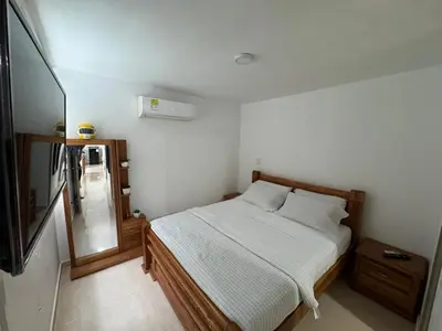 a small bedroom with a bed and a mirror at Conjunto Residencial Caribe Campestre in Coveñas
