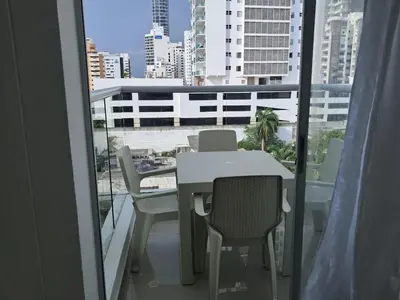 a balcony with a table and chairs and a view of a city at Dúplex en Bocagrande Cartagena Piscina, jacuzzi y a 2 cuadras del mar in Cartagena de Indias