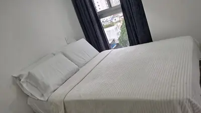 a white bed with a window in a room at Dúplex en Bocagrande Cartagena Piscina, jacuzzi y a 2 cuadras del mar in Cartagena de Indias