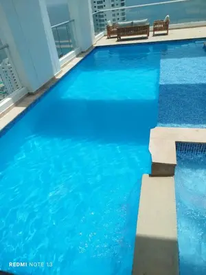 a swimming pool with blue water in a building at Dúplex en Bocagrande Cartagena Piscina, jacuzzi y a 2 cuadras del mar in Cartagena de Indias