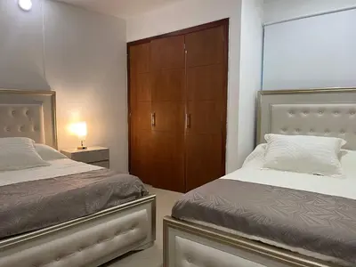 a bedroom with two beds and a wooden cabinet at New apartment with a beautiful view 2002 in Cartagena de Indias