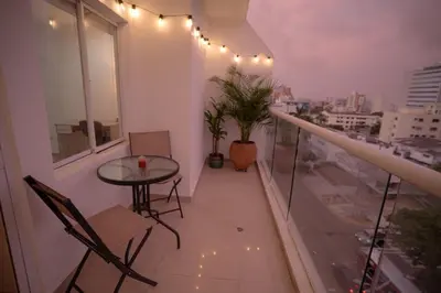 a balcony with a table and chairs and a view of a city at Stunning Caribbean-Inspired PH next to Viva Mall in Barranquilla