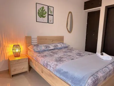 a bedroom with a bed and a lamp on a night stand at Stunning Caribbean-Inspired PH next to Viva Mall in Barranquilla