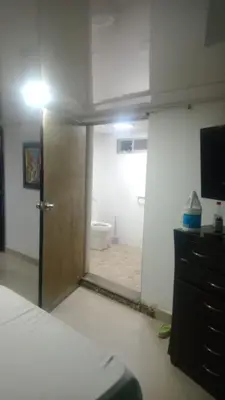 a bedroom with a door to a bathroom with a toilet at cabaña frente al mar de cartagena in Cartagena de Indias