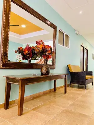 a mirror and a vase with flowers on a table at Hotel El Viajero #2 in Cartagena de Indias
