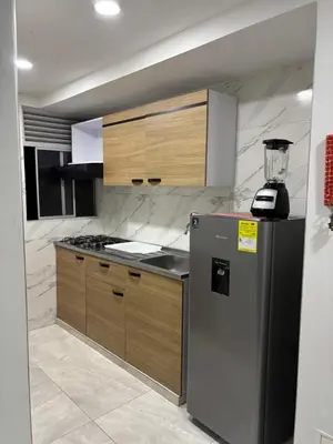 a kitchen with a stainless steel refrigerator and wooden cabinets at Apartamento en Zona Estratégica de Barranquilla in Barranquilla