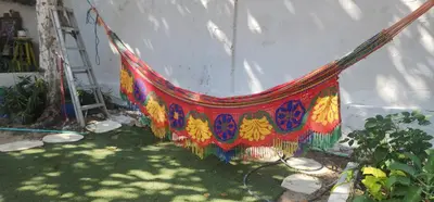 a colorful hammock is leaning against a wall at Casa de Playa Salgar in Puerto Colombia