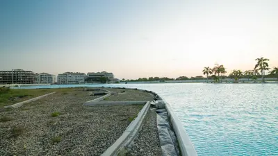 a large body of water with buildings and palm trees at Exclusive New 1-BR Apartment in Baia Kristal Kabo in Los Arrayanes