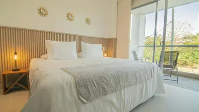 a bedroom with a large white bed with a window at Exclusive New 1-BR Apartment in Baia Kristal Kabo in Los Arrayanes