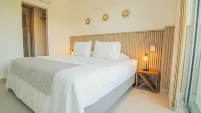 a bedroom with a large bed with white sheets and pillows at Exclusive New 1-BR Apartment in Baia Kristal Kabo in Los Arrayanes