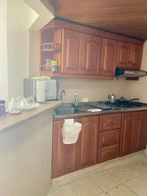 a kitchen with wooden cabinets and a sink and a microwave at Altamar suite Cabrero in Cartagena de Indias