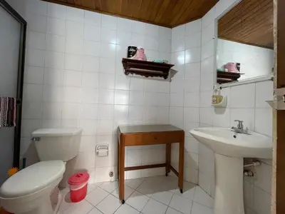 a white bathroom with a toilet and a sink at Altamar suite Cabrero in Cartagena de Indias