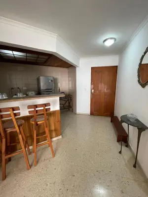 a room with a kitchen with a counter and chairs at Altamar suite Cabrero in Cartagena de Indias