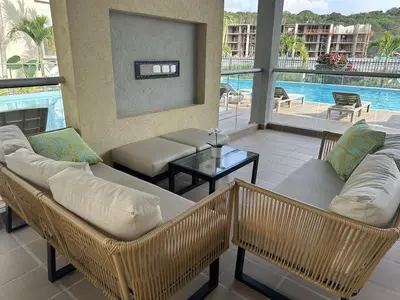 a living room with wicker furniture and a pool at Apartamento Familiar cerca del la Playa in Cartagena de Indias