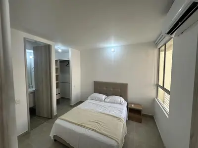 a white bedroom with a bed and a window at Apartamento Familiar cerca del la Playa in Cartagena de Indias