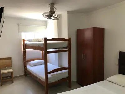 a room with two bunk beds and a cabinet at Hotel Aeromar Central in Santa Marta