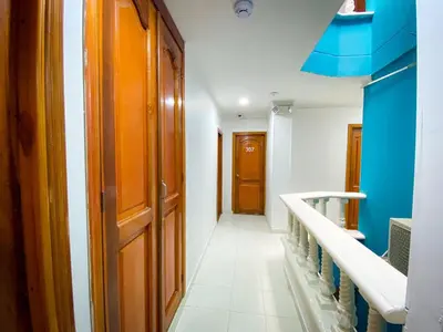 a hallway with a wooden door and a staircase at Hotel Aeromar Central in Santa Marta