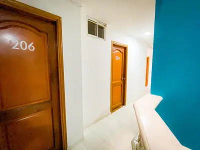 a hallway with a wooden door and a white wall at Hotel Aeromar Central in Santa Marta