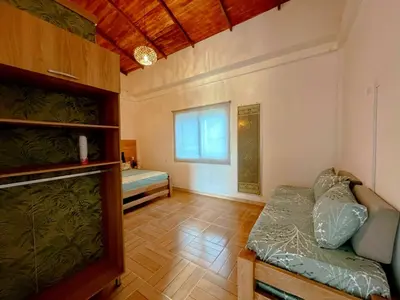 a room with a couch and a bed and a window at Villa Martina in Moñitos