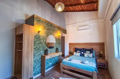 a bedroom with a bed and a wall with a mural at Villa Martina in Moñitos