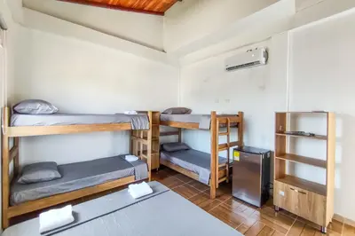 a room with three bunk beds and a refrigerator at Villa Martina in Moñitos