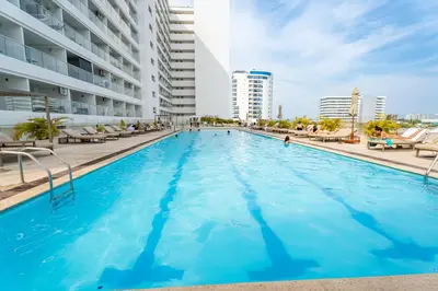 a swimming pool with blue water in a building at Magica Cartagena Suite in Cartagena de Indias