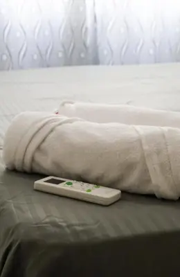 a remote control sitting on a bed with a blanket at Apartamento 3 hab a paso del mar in Cartagena de Indias