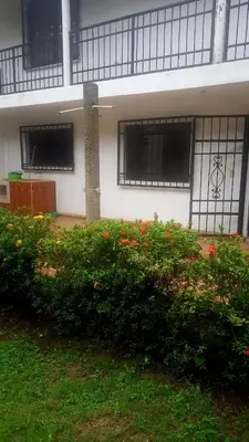 a building with windows and a bush with flowers at Cabaña Turística a Pasos del Mar, Ideal para Grupo in San Antero