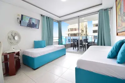 a hotel room with two beds and a balcony at apartamento con balcon p6 in Cartagena de Indias