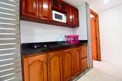 a kitchen with wooden cabinets and a microwave at apartamento con balcon p6 in Cartagena de Indias