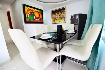 a dining room with a table and white chairs at apartamento con balcon p6 in Cartagena de Indias