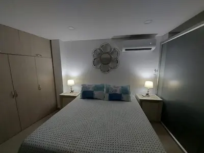 a bedroom with a large bed with two lamps on both sides at Apartaestudio al frente del Mar in Cartagena de Indias