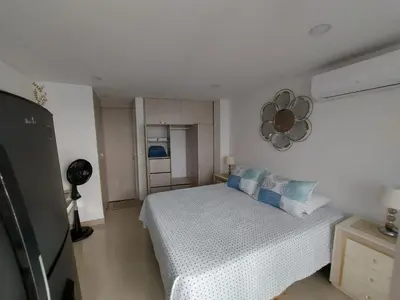 a bedroom with a bed and a mirror on the wall at Apartaestudio al frente del Mar in Cartagena de Indias