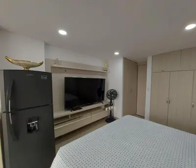 a bedroom with a black refrigerator and a television at Apartaestudio al frente del Mar in Cartagena de Indias