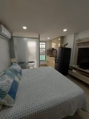 a bedroom with a bed and a kitchen with a refrigerator at Apartaestudio al frente del Mar in Cartagena de Indias