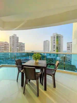a table and chairs on a balcony with a view of a city at Espectacular apartamento vista al mar in Cartagena de Indias