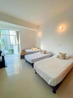 a bedroom with two beds and a couch in it at Espectacular apartamento vista al mar in Cartagena de Indias