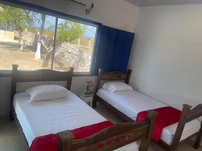 two beds in a room with a window at Villa Liz in Puebloviejo