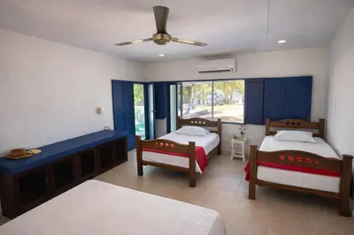 a bedroom with two beds and a ceiling fan at Villa Liz in Puebloviejo