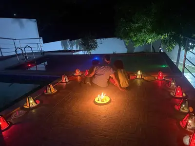 a man and a child sitting on the ground with candles at Private pool cabin near the sea Puerto Velero in Tubará